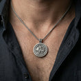 Load image into Gallery viewer, Oxidized Lion of Judah rotating pendant worn on the neck in a lifestyle jewelry shot, styled against the chest for a bold and symbolic look
