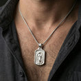 Load image into Gallery viewer, Polished silver Virgin of Guadalupe pendant worn on the neck in a close lifestyle frame, highlighting the detailed Marian figure and sacred icon design
