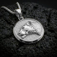 Load image into Gallery viewer, Polished silver lioness necklace with sculpted female lion portrait, textured fur detailing, and refined circular medallion design placed on textured volcanic rock in a premium studio product shot
