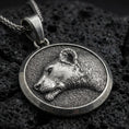 Load image into Gallery viewer, Oxidized lioness pendant with detailed feline profile, round medallion frame, and elegant wild cat silhouette displayed on dark volcanic rock in a close-up luxury jewelry composition
