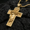 Load image into Gallery viewer, Gold plated Jesus crucifix pendant with profile portrait, crown of thorns, and engraved cross form showcased on black volcanic rock in a refined macro jewelry image
