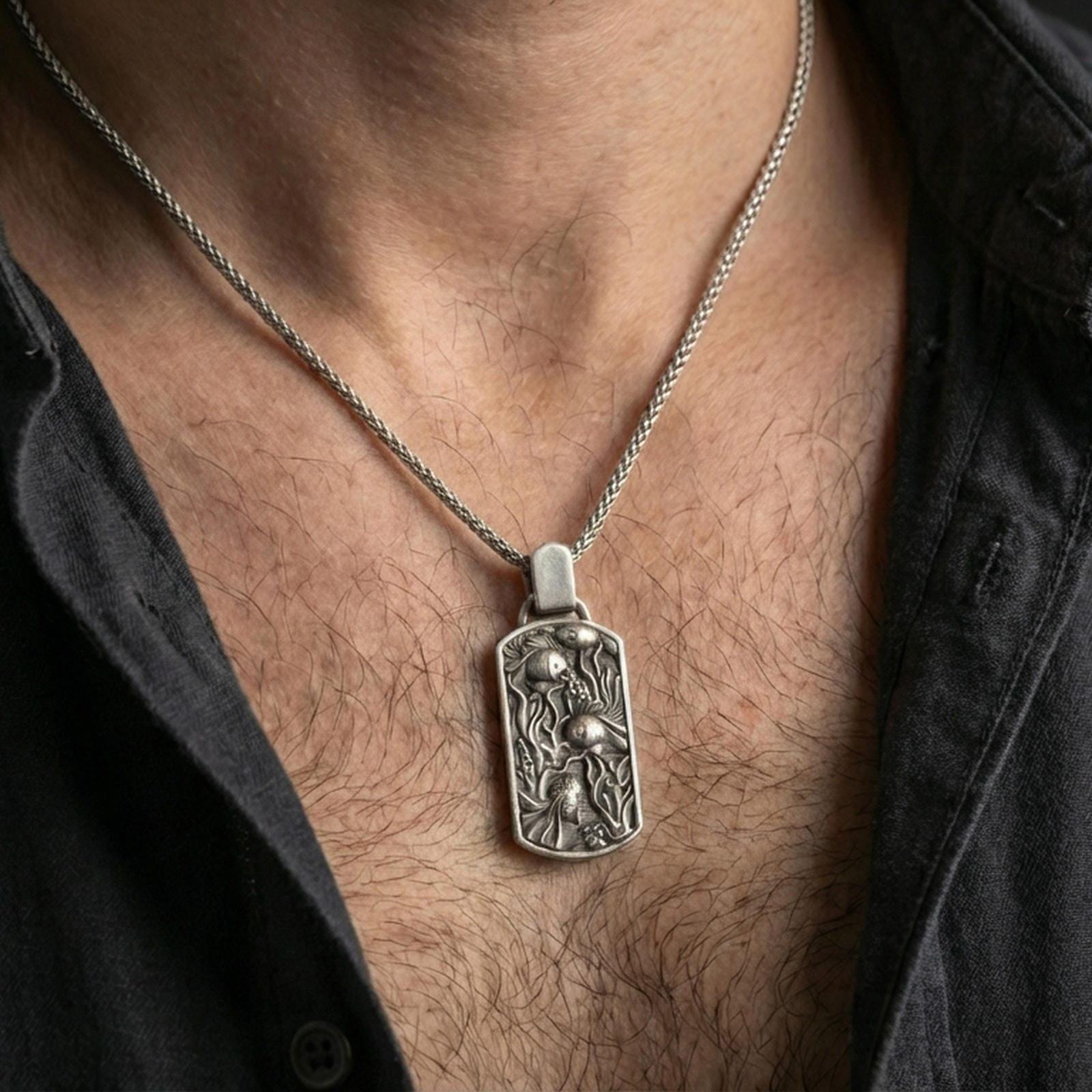 Oxidized sea life pendant with fish tank scene worn on the neck in a lifestyle jewelry shot, styled against the chest for a playful and ocean-inspired statement look