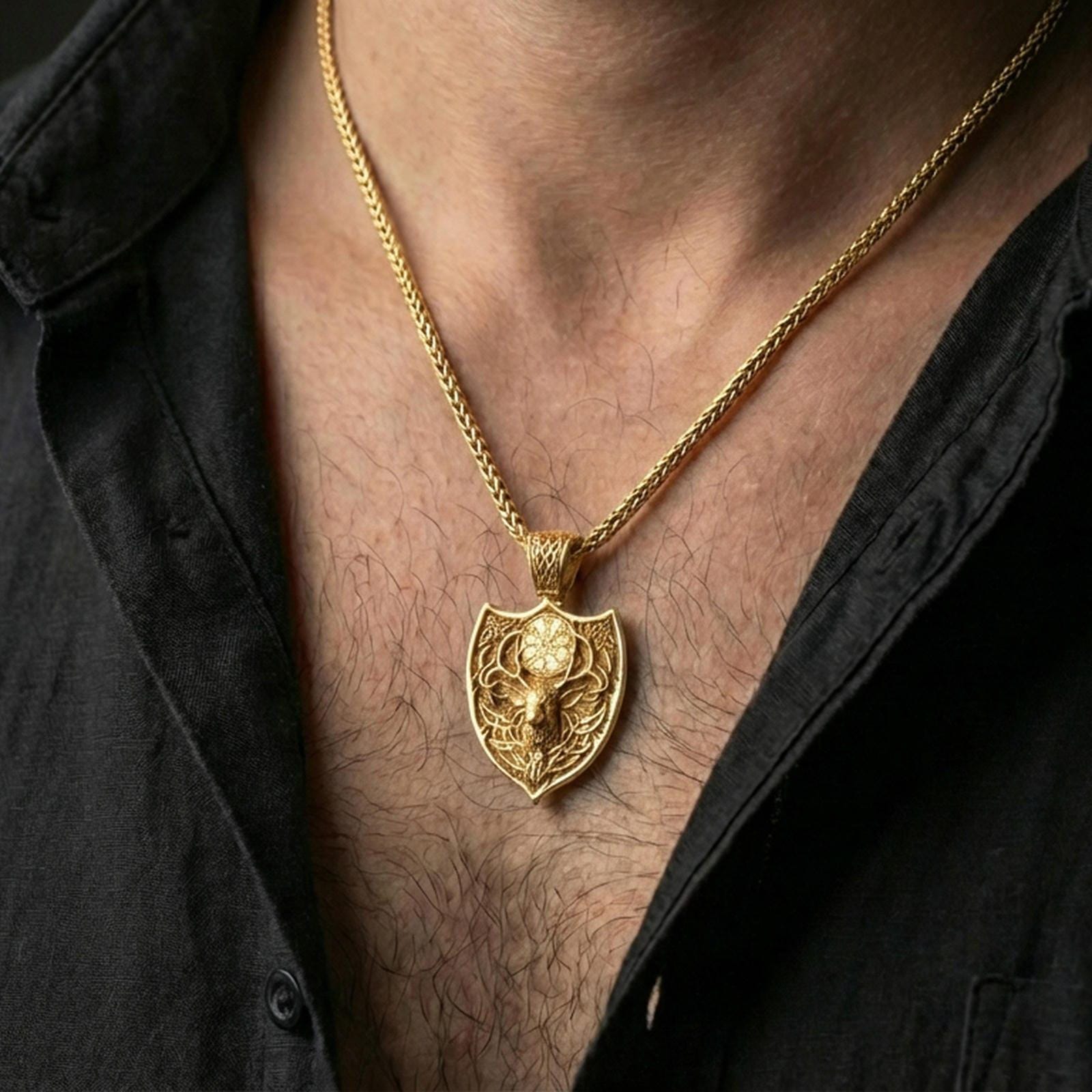Gold plated Celtic deer pendant with detailed stag relief, Nordic symbol, and shield-inspired form worn on the neck in a premium lifestyle composition with strong Viking jewelry styling