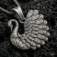 Load image into Gallery viewer, Oxidized swan pendant with detailed feather engraving, graceful curved neck, and elegant bird silhouette displayed on dark volcanic rock in a close-up luxury jewelry composition
