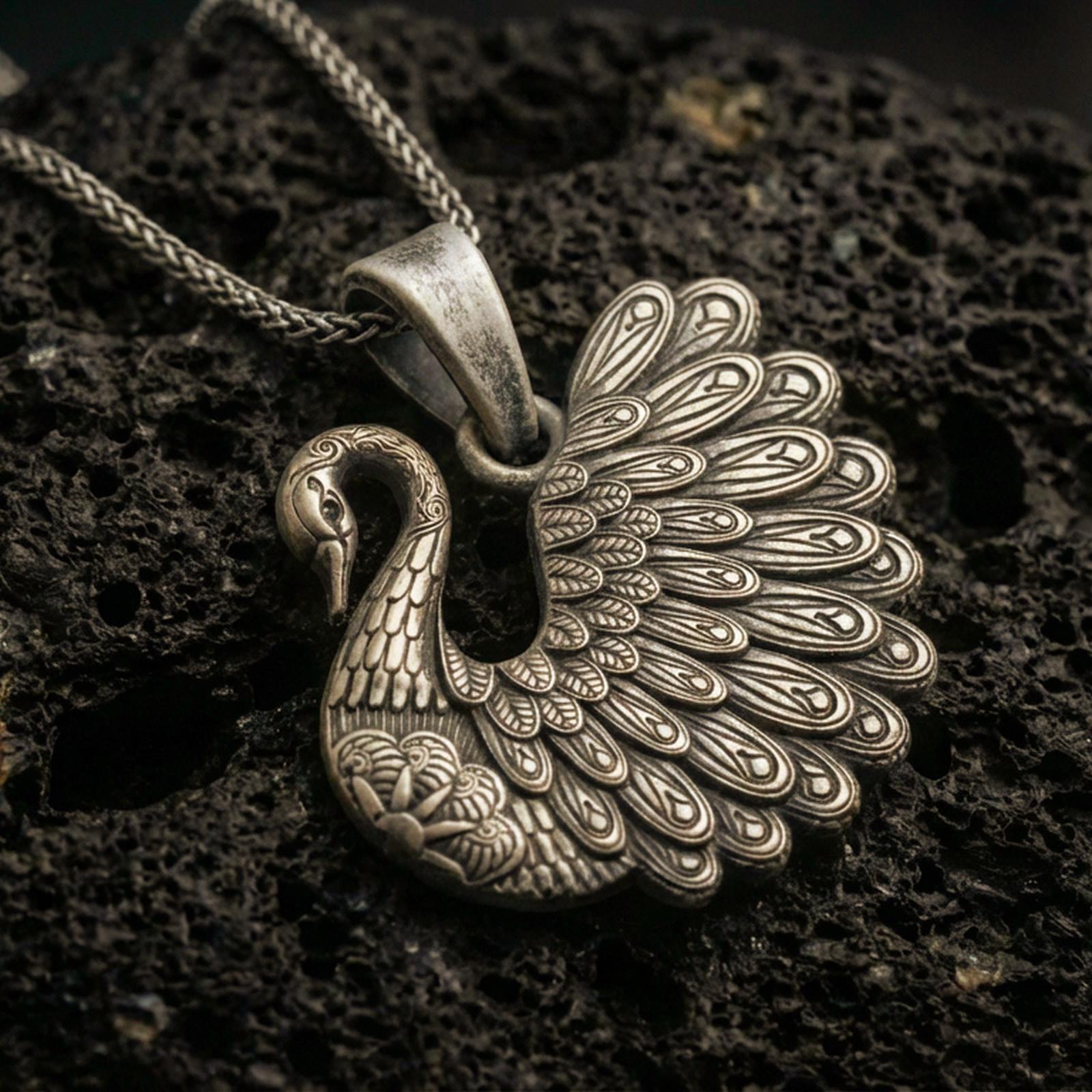 Bronze swan pendant with detailed feather engraving, graceful curved neck, and elegant bird silhouette displayed on dark volcanic rock in a close-up luxury jewelry composition