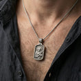 Load image into Gallery viewer, Oxidized Saint Francis pendant worn on the neck in a lifestyle jewelry shot, styled against the chest for a devotional and timeless look

