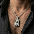 Load image into Gallery viewer, Polished silver Saint Joseph medallion with Child Jesus worn on the neck in a close lifestyle frame, highlighting the detailed sacred portrait and halo relief
