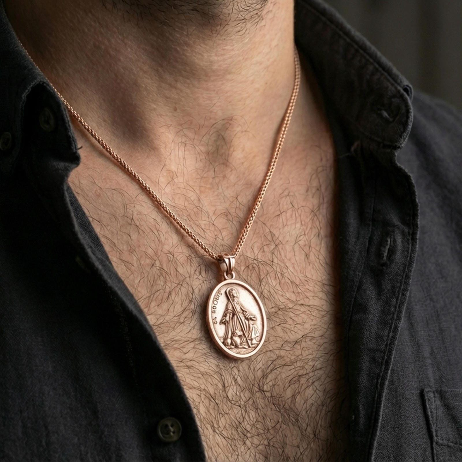 Rose gold plated religious Saint Rochus medal with saint figure and dog companion worn on the neck in a refined lifestyle shot with a warm and elegant presentation