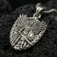 Load image into Gallery viewer, Oxidized Archangel Michael pendant with shield silhouette, winged warrior figure, sword, and armor detail displayed on dark volcanic rock in a close-up luxury jewelry composition
