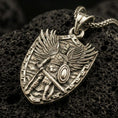 Load image into Gallery viewer, Bronze Archangel Michael pendant with shield silhouette, winged warrior figure, sword, and armor detail displayed on dark volcanic rock in a close-up luxury jewelry composition
