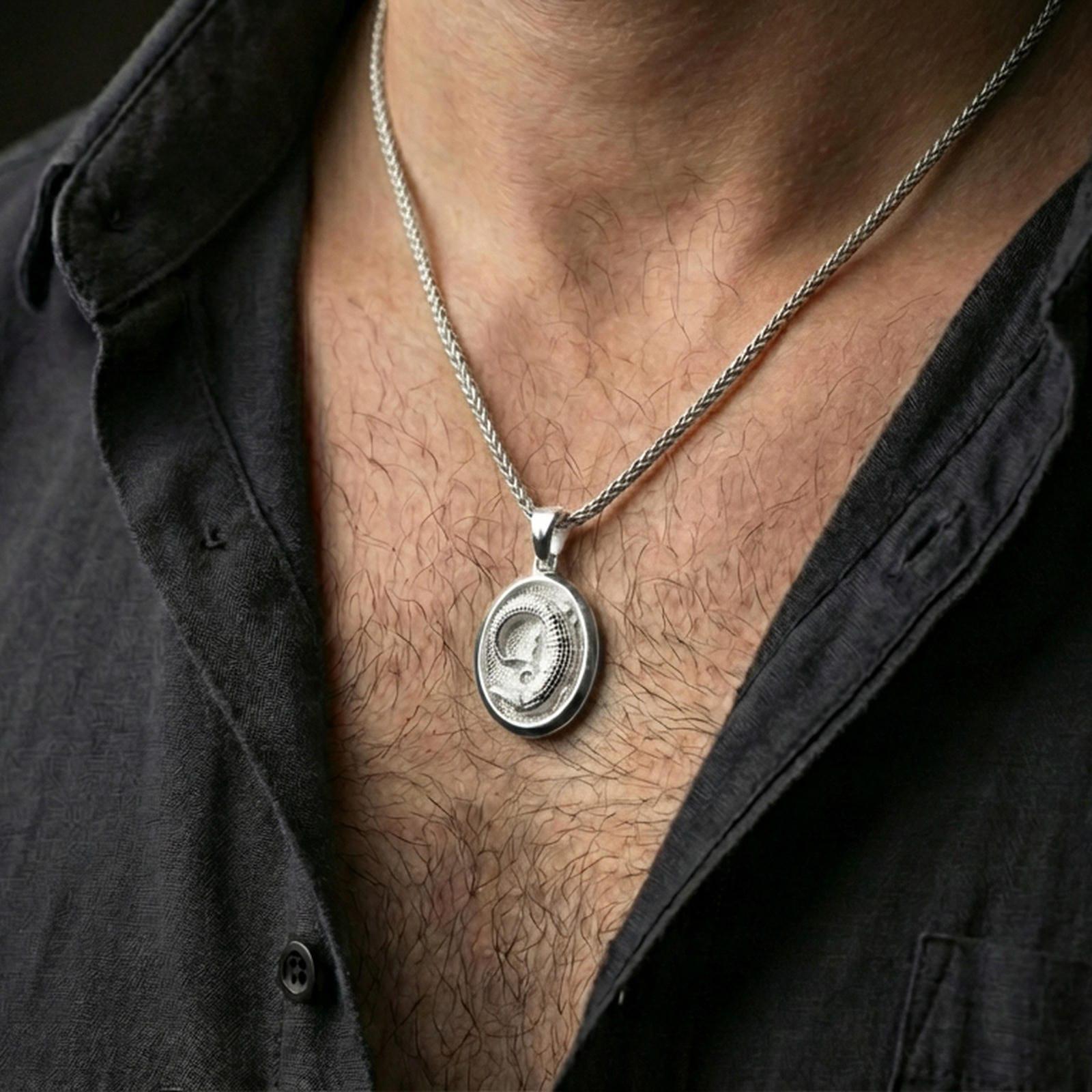 Polished silver crocodile pendant necklace worn on the neck, captured in a close lifestyle shot against the chest for a refined everyday look.