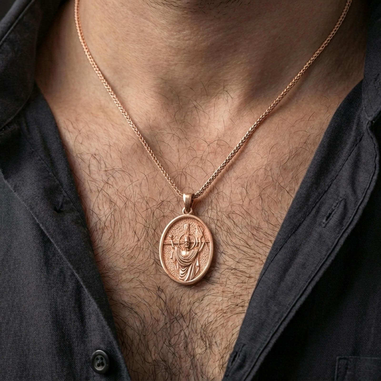 Rose gold plated Jesus resurrection pendant with haloed figure and banner detail worn on the neck in a refined lifestyle shot with a warm and elegant presentation