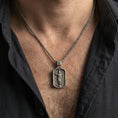 Load image into Gallery viewer, Oxidized Jesus pendant with ascending Christ figure worn on the neck in a lifestyle jewelry shot, styled against the chest for a bold and devotional look
