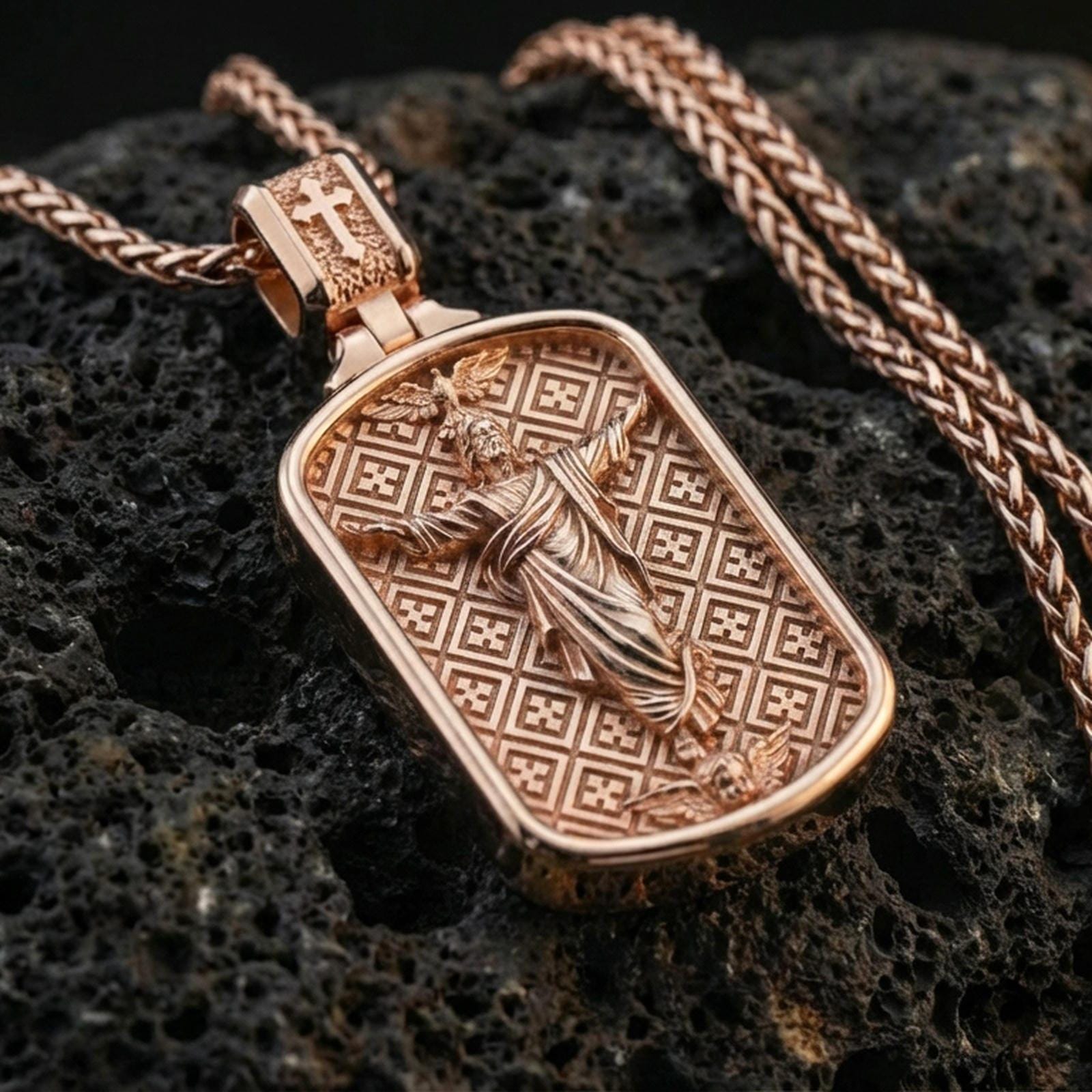 Rose gold plated religious Jesus pendant with framed ascension scene, patterned background, and sculpted devotional relief resting on volcanic rock in an elegant close-up product presentation