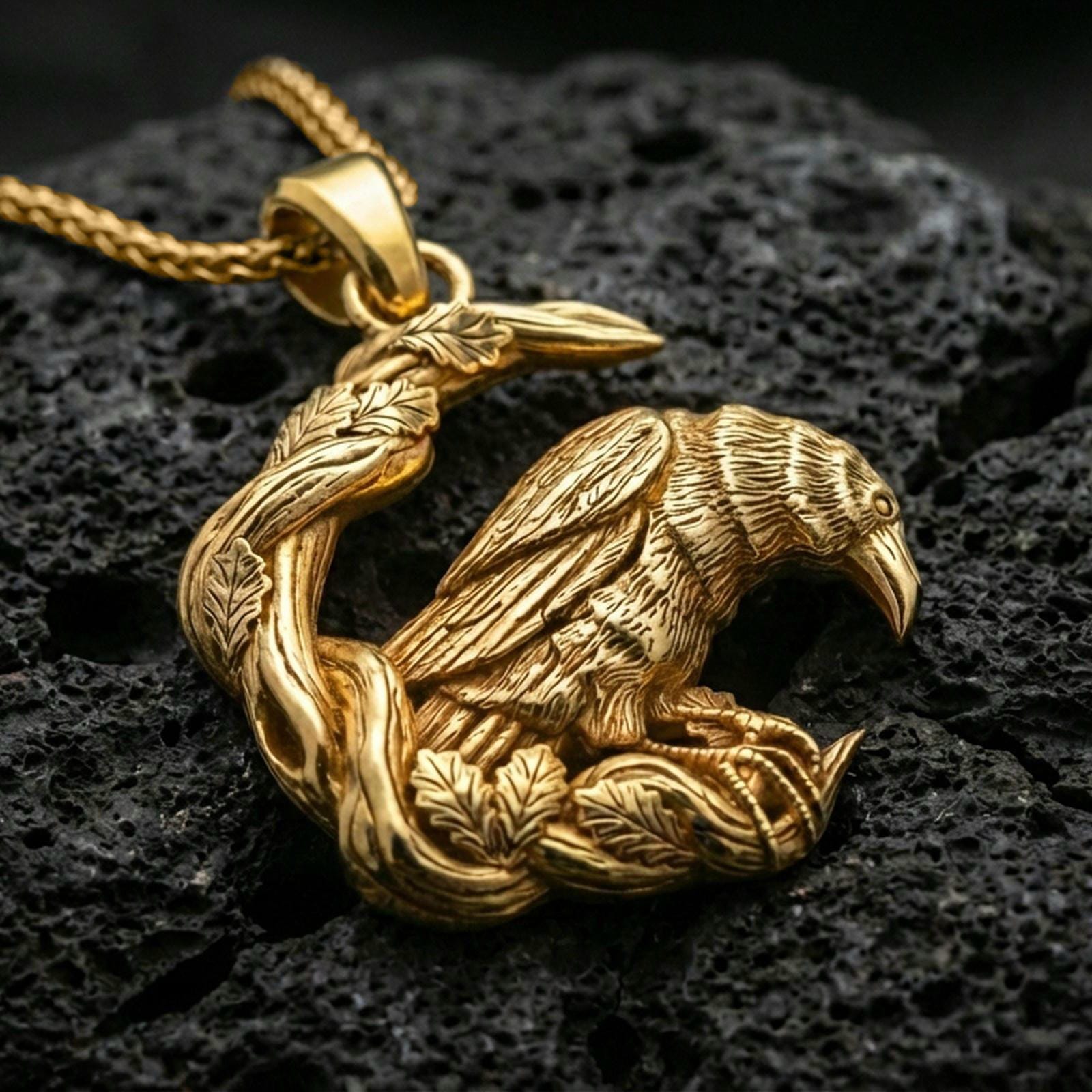 Gold plated Viking raven pendant necklace shown on porous volcanic rock, highlighting the sculpted bird and entwined woodland frame.
