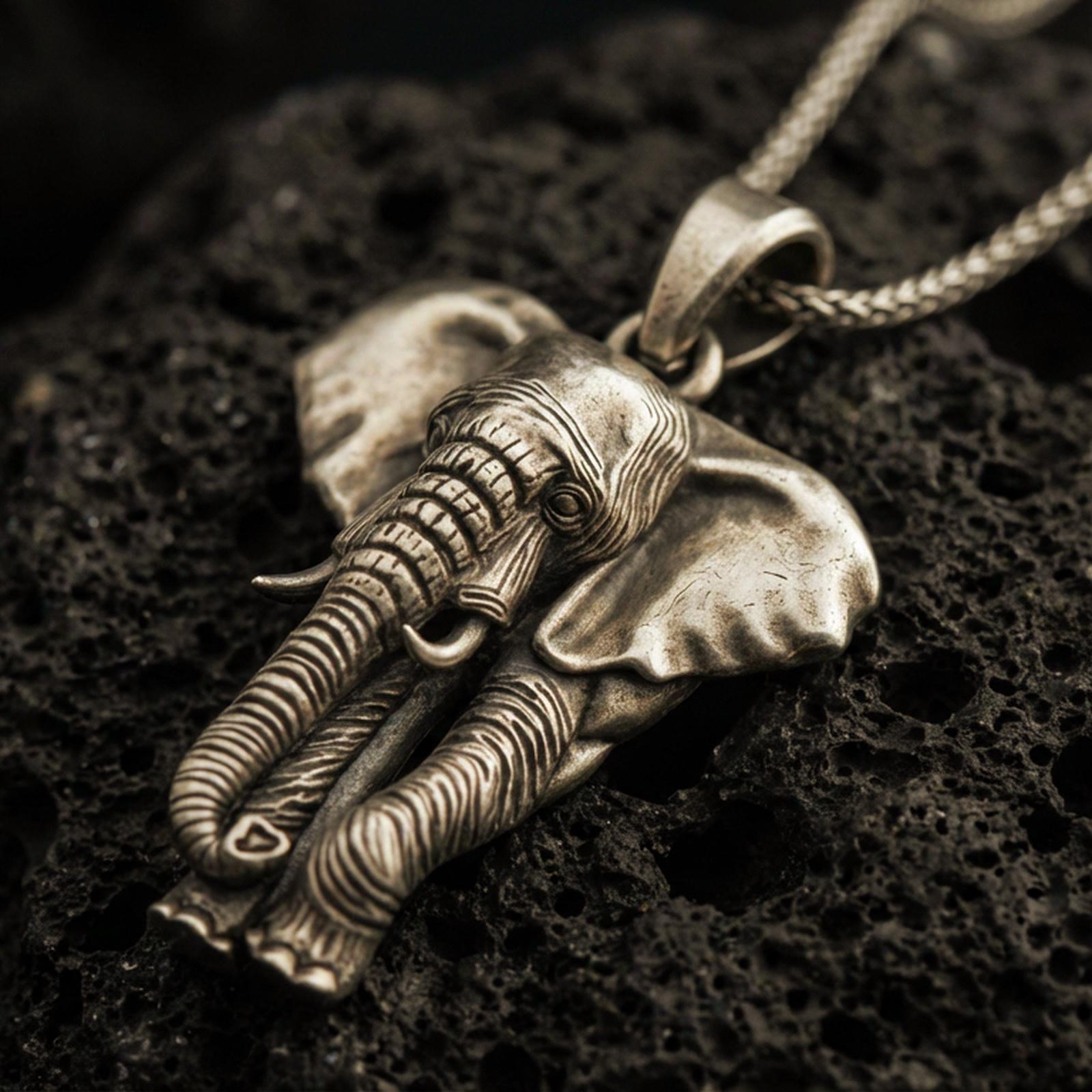 Bronze elephant pendant necklace with an oxidized finish resting on textured volcanic rock, captured in a close-up premium studio composition.