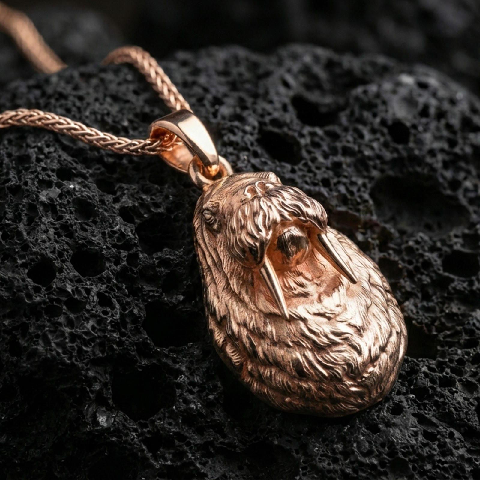 Rose gold plated walrus pendant necklace on dark volcanic rock, photographed in a detailed premium studio macro view.