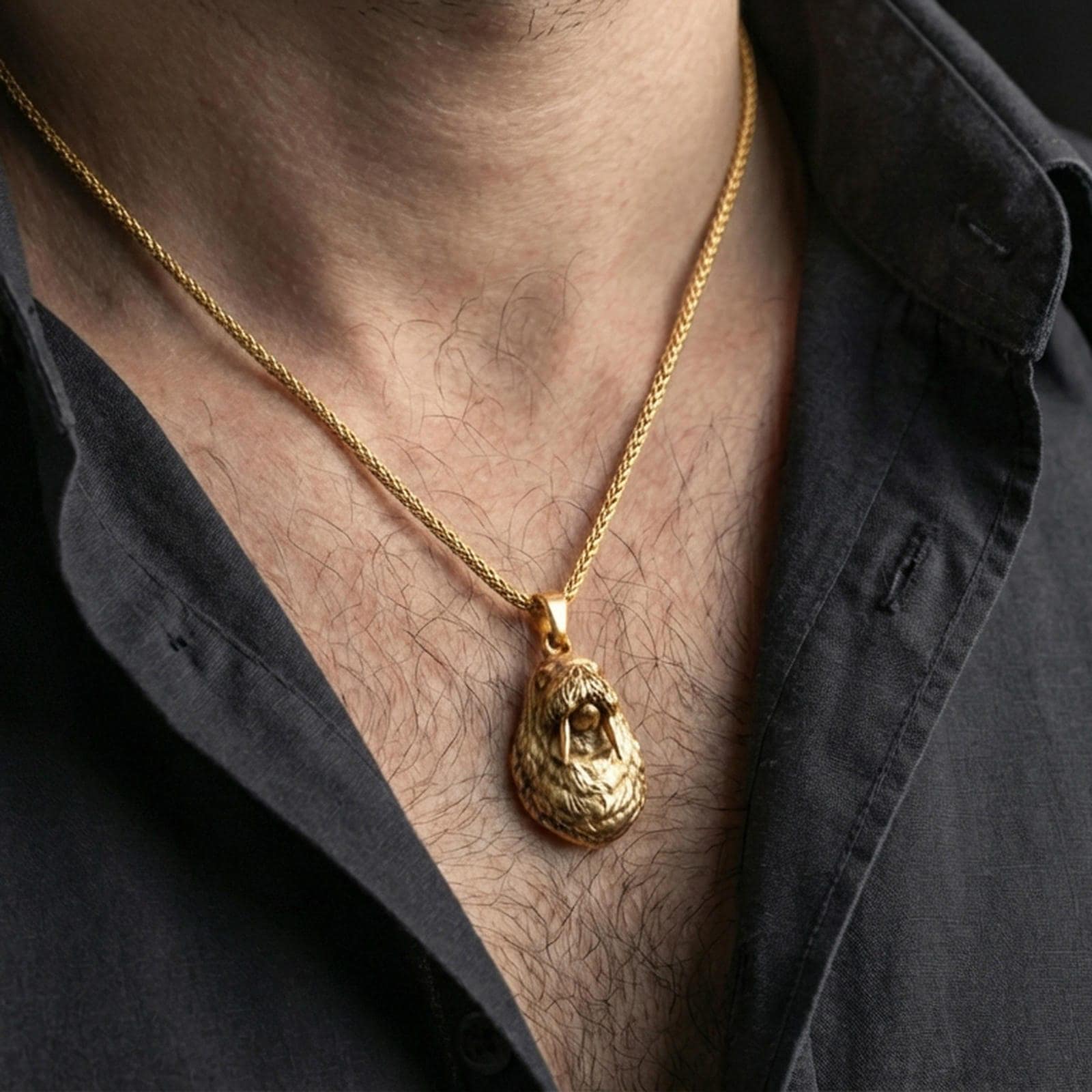 Gold plated walrus pendant necklace worn on the neck, captured on a human model in a premium dark-toned lifestyle frame.