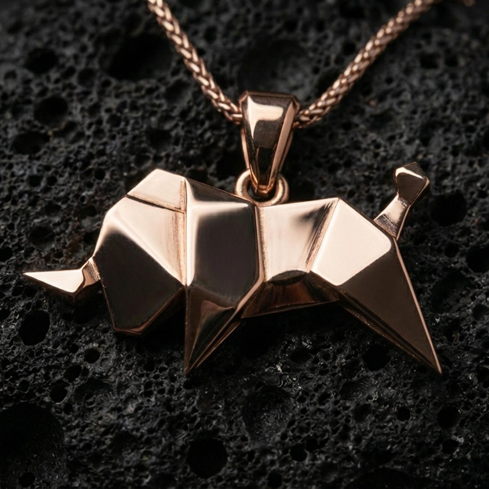 Rose gold plated origami elephant pendant necklace on dark volcanic rock, photographed in a detailed premium studio macro view.