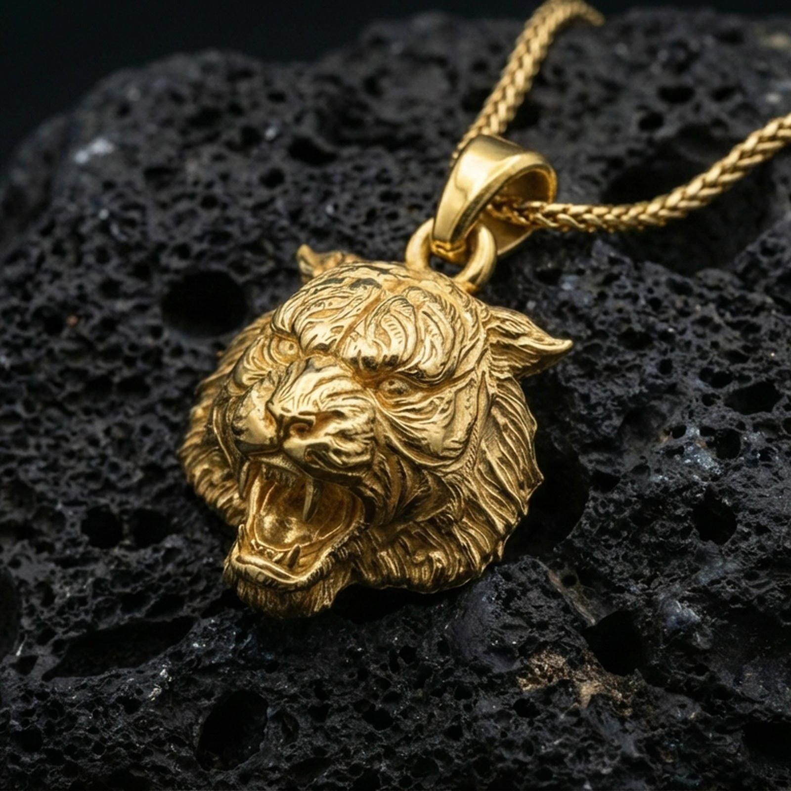 Gold plated tiger lion pendant necklace presented on porous volcanic rock, highlighting the fierce animal head design in a luxurious close-up jewelry image.