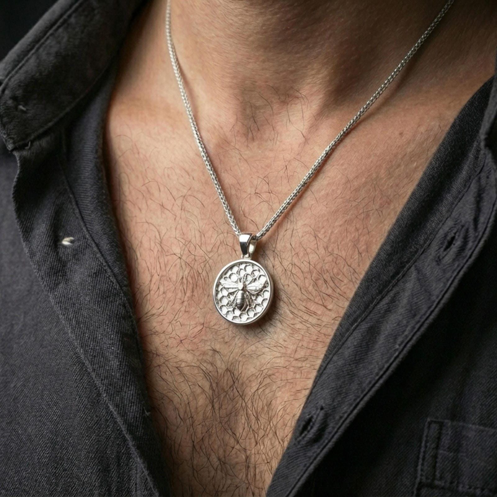 Polished silver bee pendant necklace worn on the neck, shown against the chest in a clean and elegant everyday wear composition.