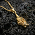 Load image into Gallery viewer, Gold plated hanging bat pendant necklace presented on porous volcanic rock, highlighting the gothic animal form in a luxurious close-up jewelry image.
