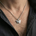 Load image into Gallery viewer, Oxidized origami butterfly pendant necklace worn on the neck, styled in a dark lifestyle portrait with an open shirt and masculine presentation.
