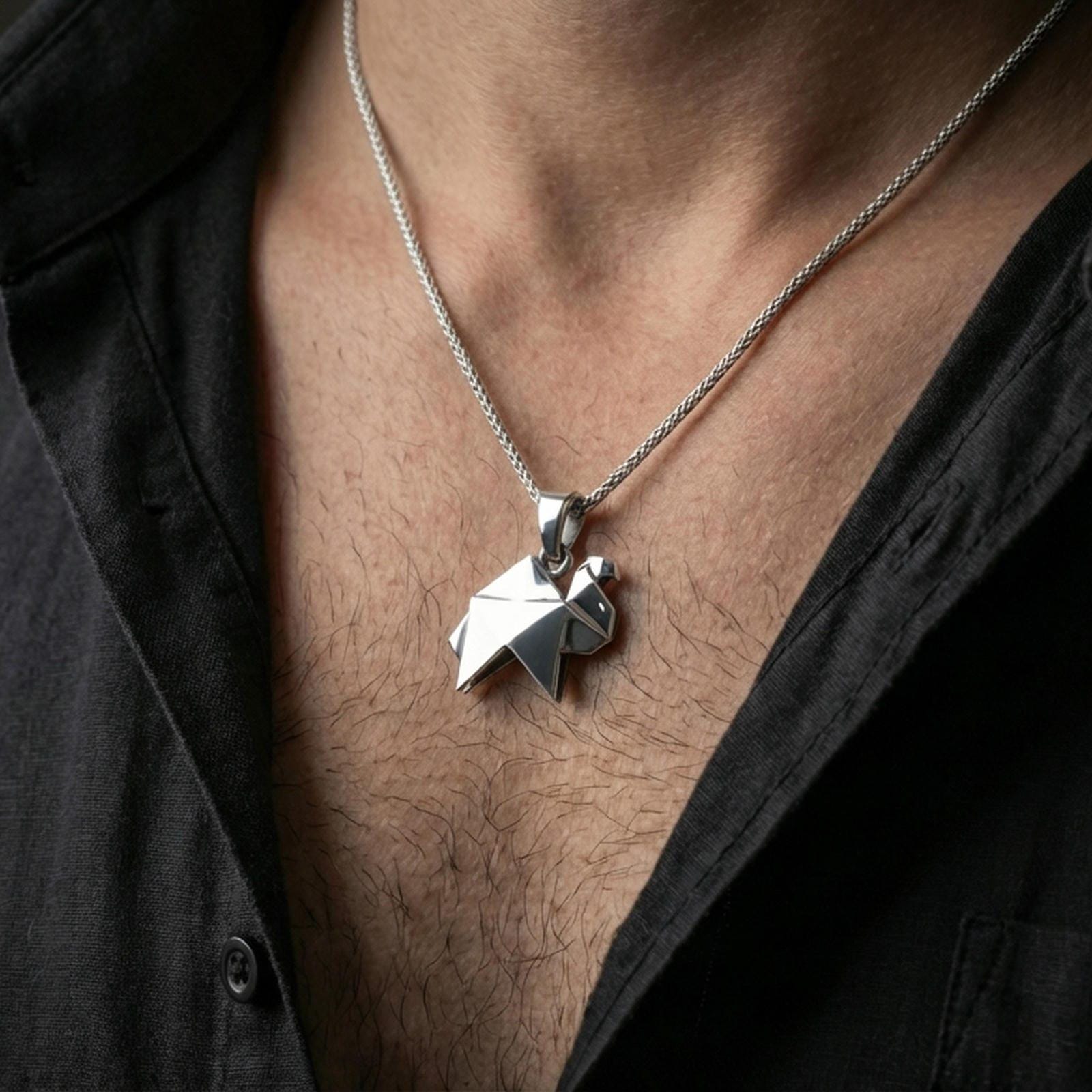Polished silver origami camel pendant necklace worn on the neck, shown against the chest in a clean and elegant everyday wear composition.