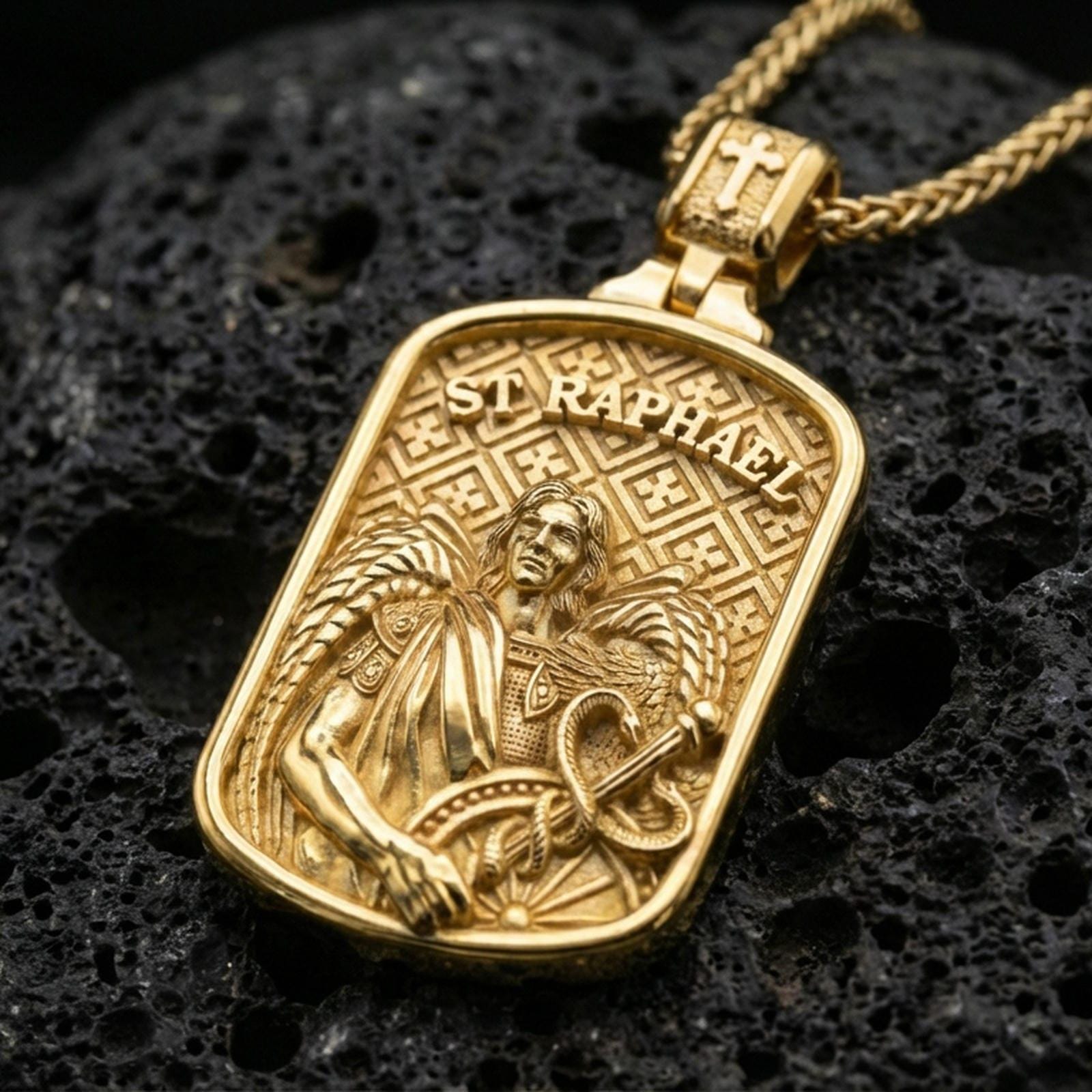Gold plated St Raphael archangel pendant necklace on black volcanic rock with bold saint lettering and relief.