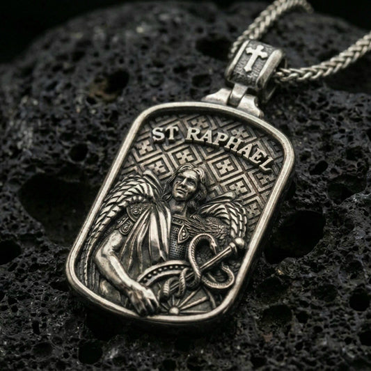 Oxidized 925 sterling silver St Raphael archangel pendant on black volcanic rock with detailed saint relief.