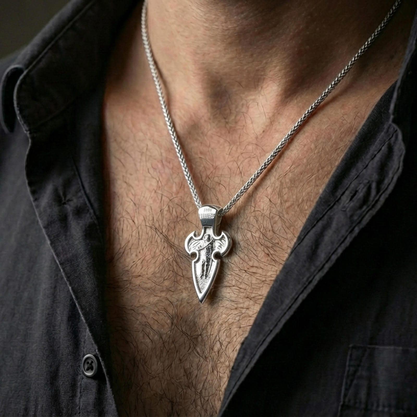 Polished silver Saint Michael medal cross with angel warrior relief worn on the neck in a close lifestyle frame, highlighting the engraved inscription and ornate cross design