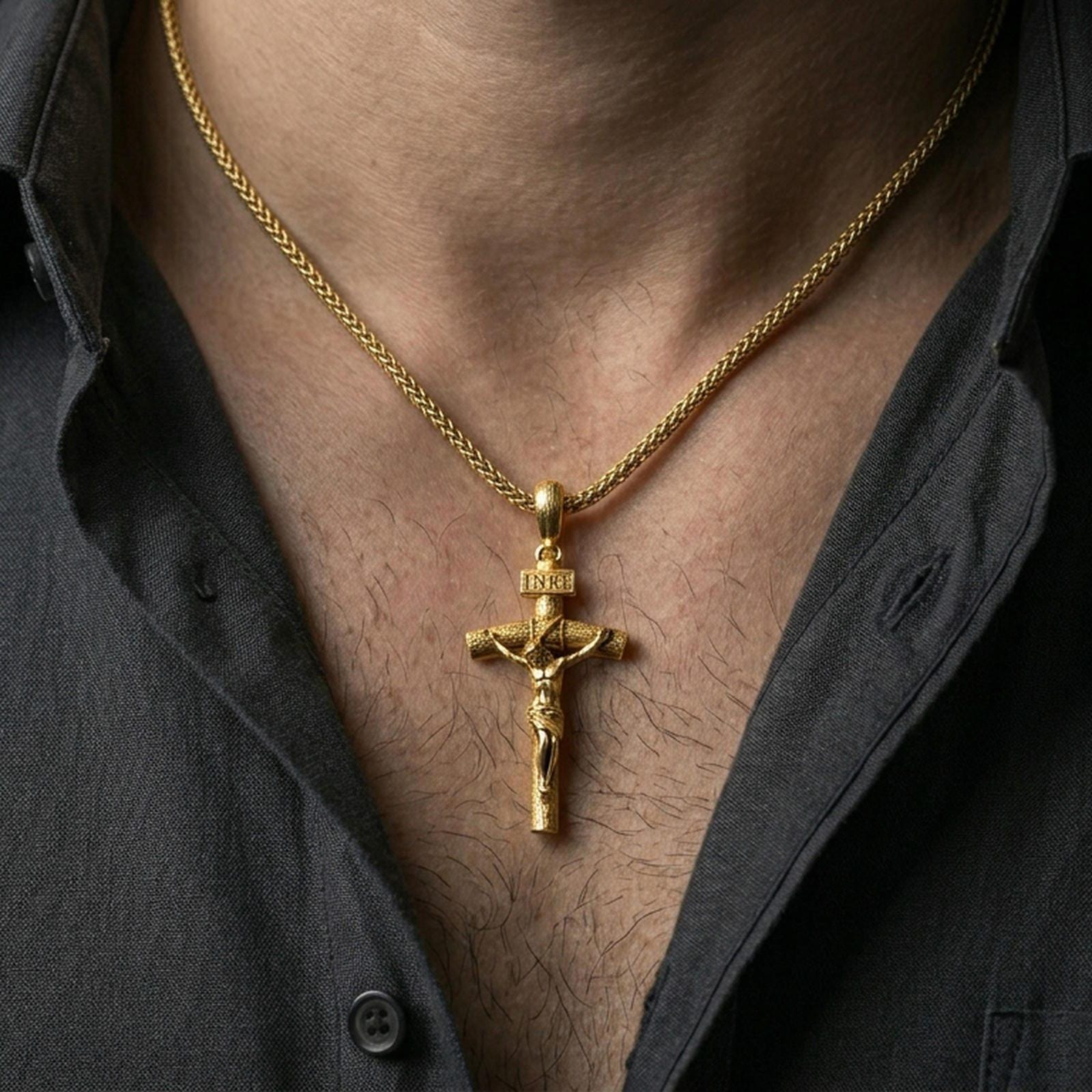 Gold plated religious crucifix pendant with raised Christ figure worn on the neck in a premium lifestyle composition with timeless Christian jewelry styling