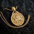 Load image into Gallery viewer, Gold plated Knights Templar seal pendant necklace presented on porous volcanic rock, highlighting the circular crusader medallion design in a luxurious close-up jewelry image.
