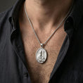 Load image into Gallery viewer, Polished silver Saint Patrick pendant necklace worn on the neck, shown against the chest in a clean and elegant everyday wear composition.
