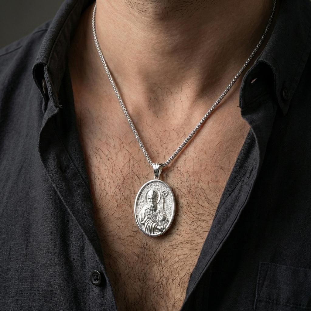 Polished silver Saint Patrick pendant necklace worn on the neck, shown against the chest in a clean and elegant everyday wear composition.