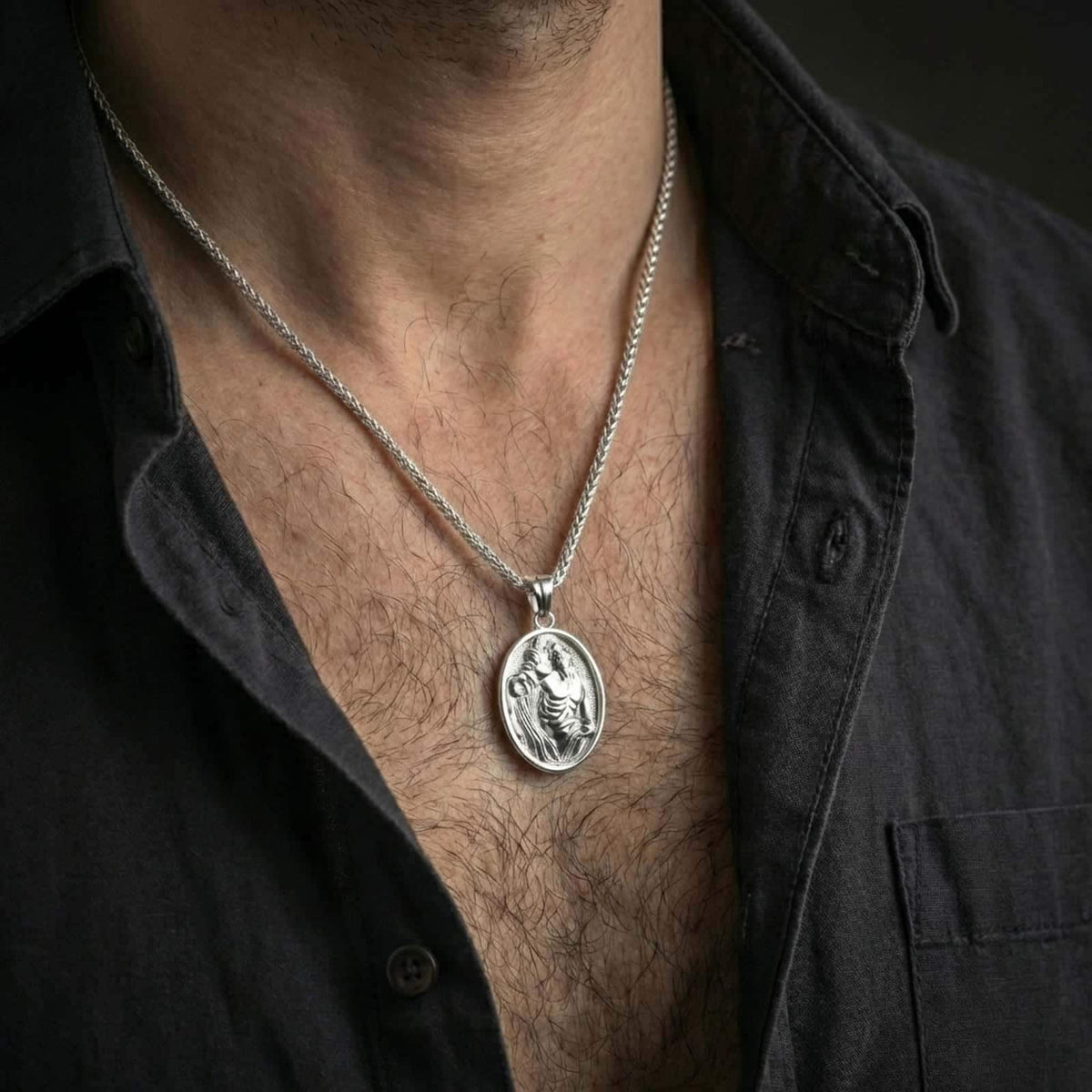 Polished silver Saint Sebastian pendant necklace worn on the neck, shown against the chest in a clean and elegant everyday wear composition.
