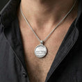 Load image into Gallery viewer, Polished silver Christian medallion with Last Supper front and Lord’s Prayer back worn on the neck in a close lifestyle frame, highlighting the round silhouette and spiritual detailing
