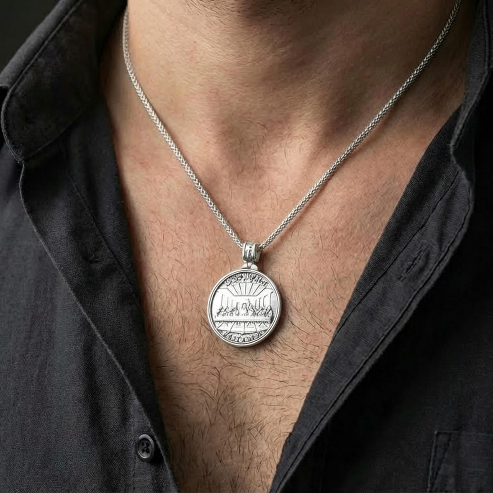Polished silver Christian medallion with Last Supper front and Lord’s Prayer back worn on the neck in a close lifestyle frame, highlighting the round silhouette and spiritual detailing