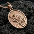 Load image into Gallery viewer, Rose gold plated Saint Christopher necklace with Child Jesus, staff motif, and classic oval devotional design resting on volcanic rock in an elegant close-up product presentation
