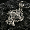 Load image into Gallery viewer, Oxidized Saint Michael cross pendant with winged archangel battle scene, openwork cross silhouette, and detailed heavenly relief displayed on dark volcanic rock in a close-up luxury jewelry composition
