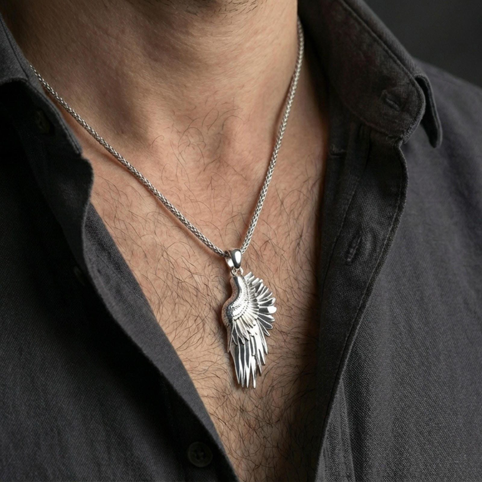 Polished silver wing necklace worn on the neck in a close lifestyle frame, highlighting the layered feather detailing and elegant celestial shape