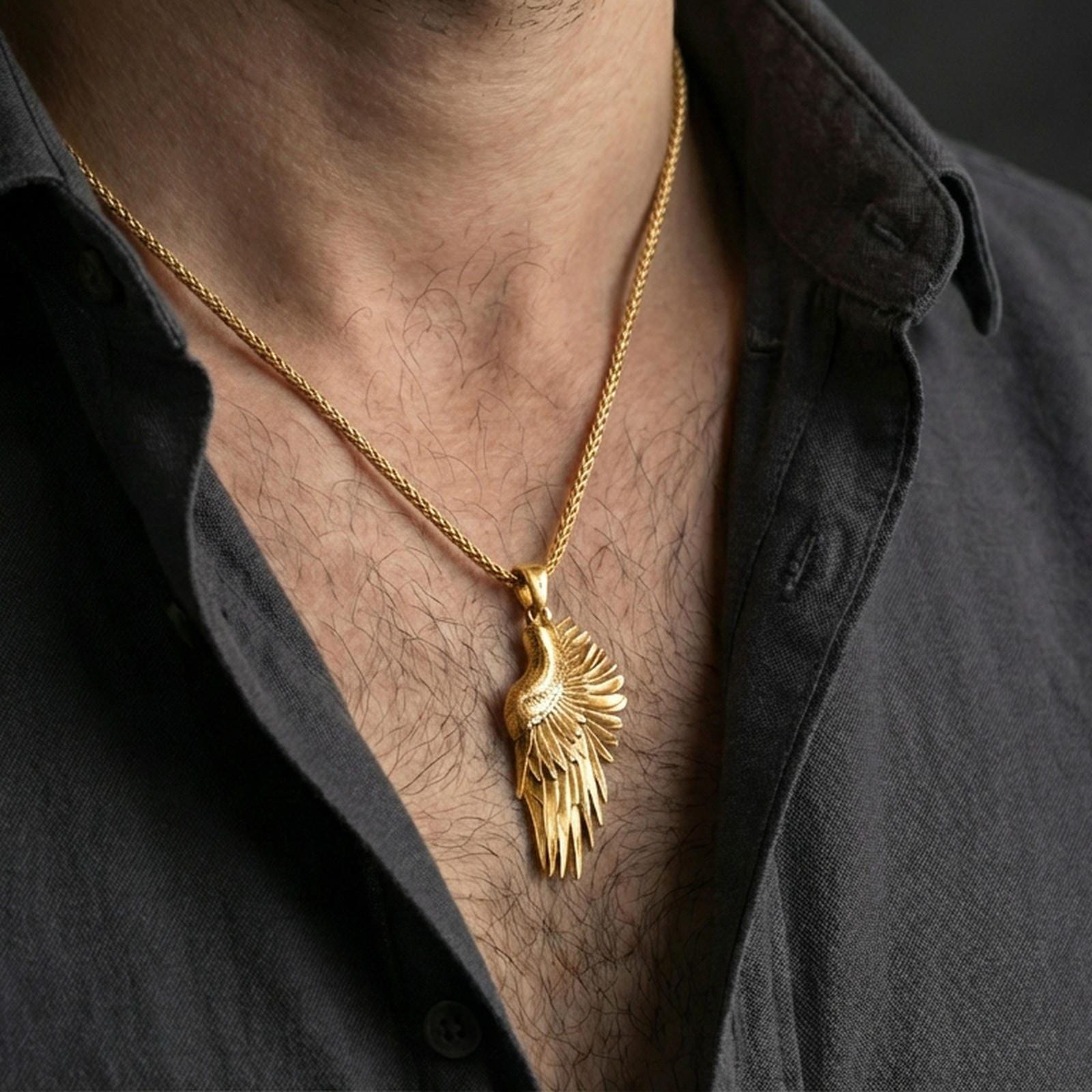 Gold plated angel wing pendant worn on the neck in a premium lifestyle composition with refined symbolic jewelry styling