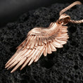 Load image into Gallery viewer, Rose gold plated wing pendant with realistic feather relief, graceful elongated silhouette, and polished ornamental finish resting on volcanic rock in an elegant close-up product presentation
