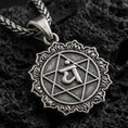 Load image into Gallery viewer, Oxidized Anahata chakra pendant with sacred symbol, hexagram motif, and sunburst border displayed on dark volcanic rock in a close-up luxury jewelry composition
