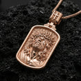Load image into Gallery viewer, Rose gold plated religious Jesus pendant with sacred portrait, crown of thorns, and framed medallion silhouette resting on volcanic rock in an elegant close-up product presentation
