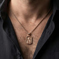 Load image into Gallery viewer, Rose gold plated Saint Anastasia pendant with haloed orthodox portrait and rounded rectangular silhouette worn on the neck in a refined lifestyle shot with a warm and elegant presentation
