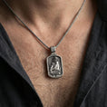 Load image into Gallery viewer, Oxidized Jesus Christ pendant with seated sacred figure and crown of thorns worn on the neck in a lifestyle jewelry shot, styled against the chest for a bold and devotional look
