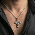 Load image into Gallery viewer, Polished silver Archangel Michael cross pendant with warrior relief worn on the neck in a close lifestyle frame, highlighting the wings, shield, and sacred battle symbolism
