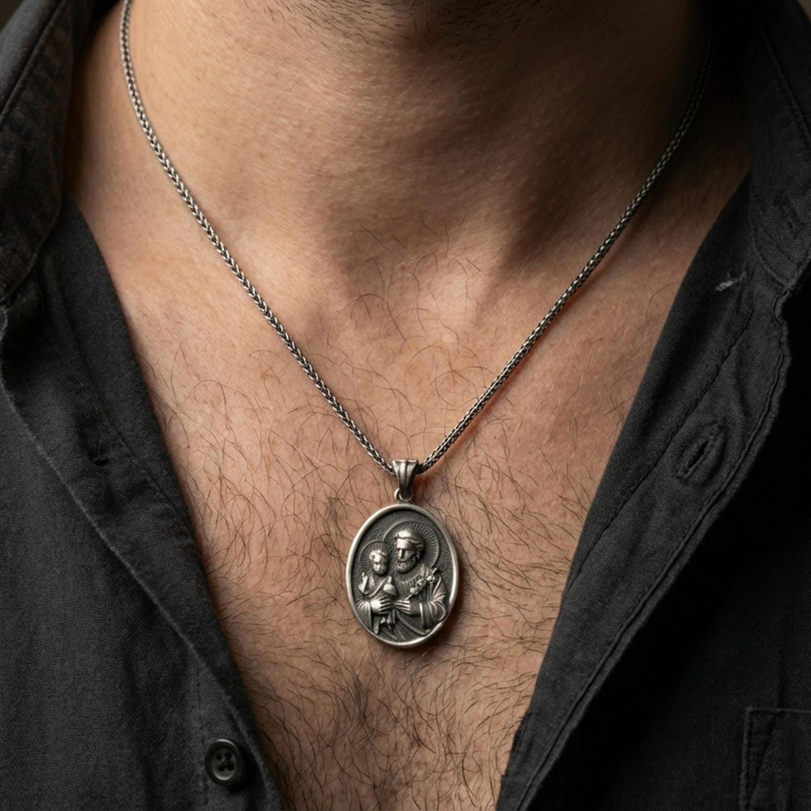 Oxidized Saint Joseph pendant with Child Jesus worn on the neck in a lifestyle jewelry shot, styled against the chest for a devotional and timeless look