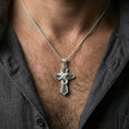 Load image into Gallery viewer, Polished silver serpent cross necklace worn on the neck in a close lifestyle frame, highlighting the coiled snake relief and dramatic gothic silhouette

